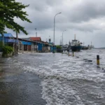 Banjir rob di kawasan pesisir Medan akibat pasang air laut tinggi yang menggenangi jalan dan permukiman warga