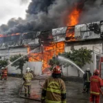 Kebakaran pabrik mainan di Medan saat petugas pemadam berupaya memadamkan api yang membakar bangunan pabrik.